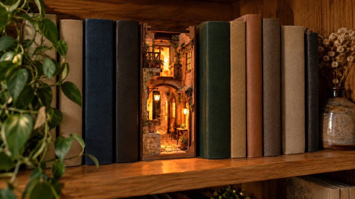 Book nook en bois allume, glisse entre des livres sur une etagere