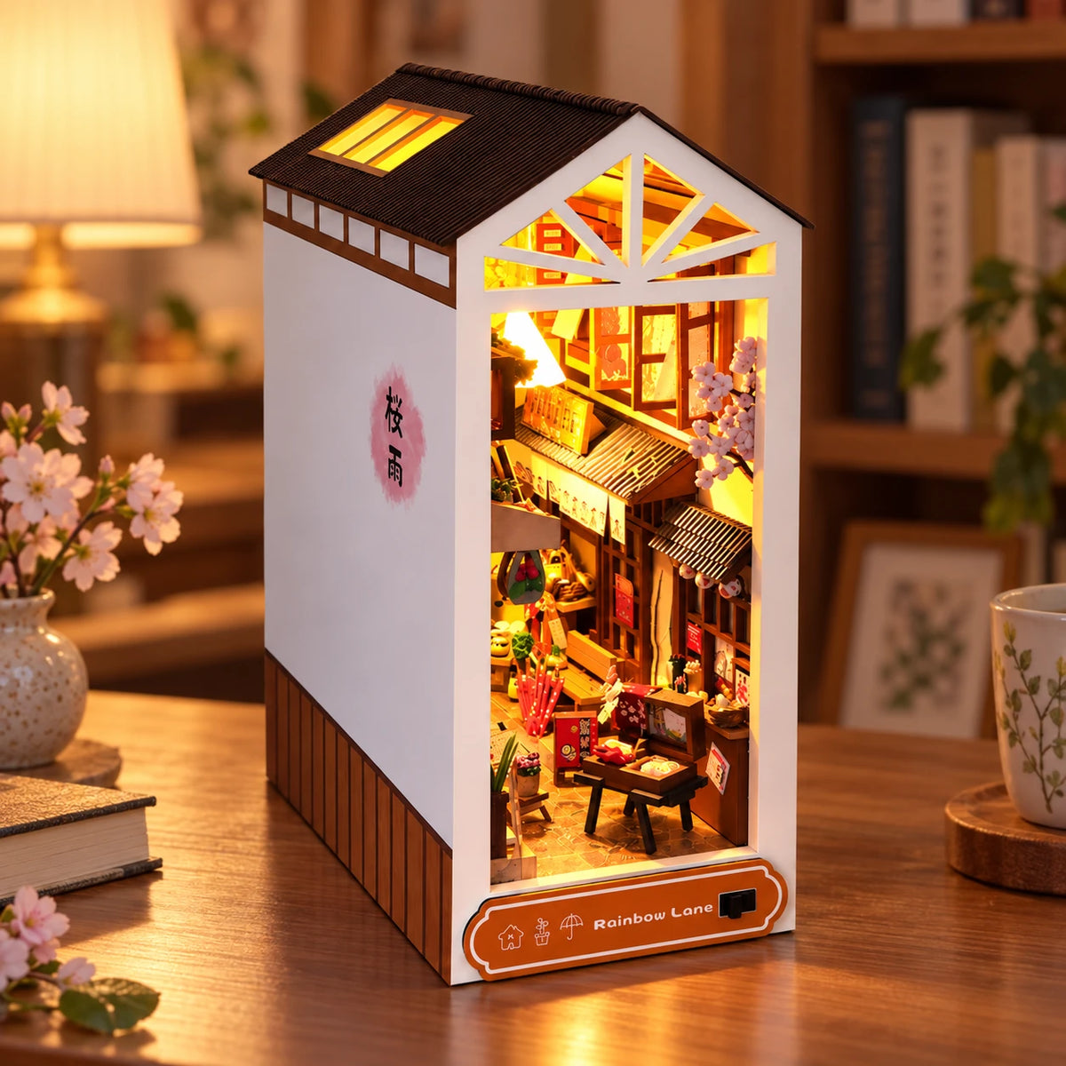 Book nook Ruelle Japonaise allumé sur un bureau, cerisier en fleurs